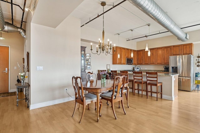 170 N NW Hwy Unit 401, Park Ridge, IL 60068 - dining space featuring light wood-type flooring, a chandelier, a towering ceiling, and baseboards