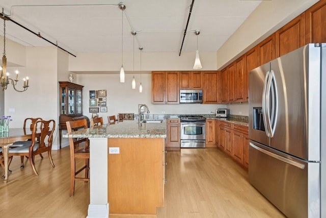 170 N NW Hwy Unit 401, Park Ridge, IL 60068 - kitchen featuring appliances with stainless steel finishes, a sink, light wood-style flooring, and brown cabinetry