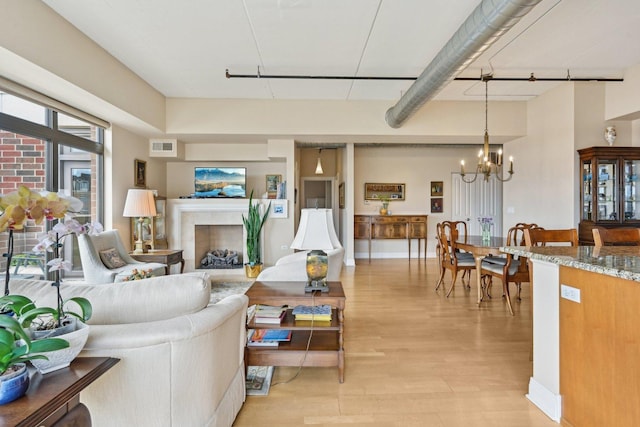 170 N NW Hwy Unit 401, Park Ridge, IL 60068 - living room featuring a chandelier, light wood-type flooring, and a fireplace