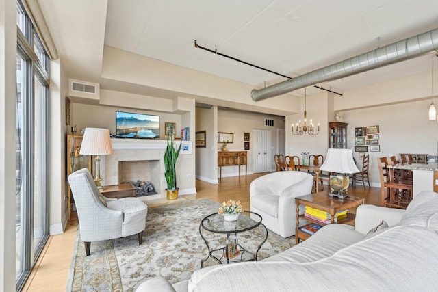170 N NW Hwy Unit 401, Park Ridge, IL 60068 - living area with a chandelier, light wood-type flooring, a tiled fireplace, and baseboards