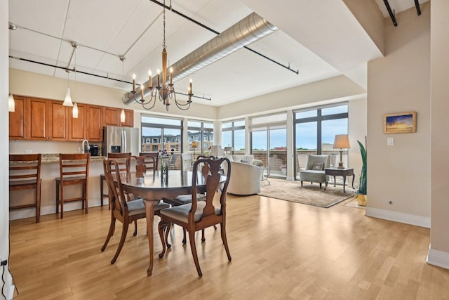 170 N NW Hwy Unit 401, Park Ridge, IL 60068 - dining area with light wood-style flooring, a chandelier, baseboards, and a high ceiling