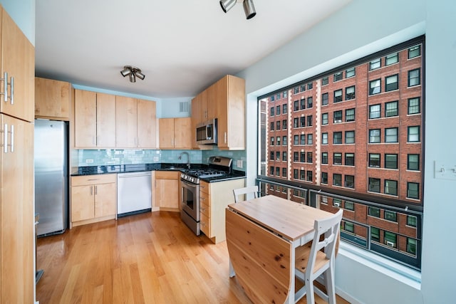 3200 N Lake Shore Dr Unit 911, Chicago, IL 60657 - kitchen featuring appliances with stainless steel finishes, light brown cabinetry, dark countertops, decorative backsplash, and light wood-style flooring