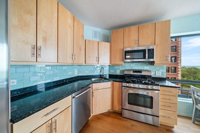 3200 N Lake Shore Dr Unit 911, Chicago, IL 60657 - kitchen with stainless steel appliances, a sink, light brown cabinets, dark stone counters, and tasteful backsplash