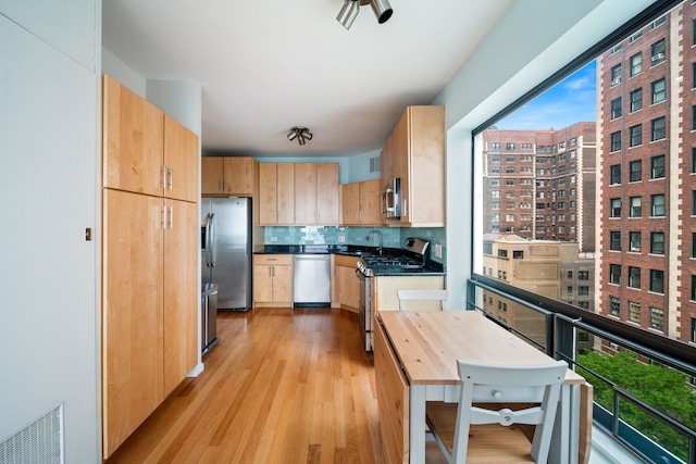 3200 N Lake Shore Dr Unit 911, Chicago, IL 60657 - kitchen featuring stainless steel appliances, light brown cabinets, light wood-type flooring, backsplash, and dark countertops