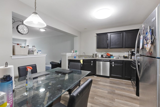 3092 Serenity Ln, Naperville, IL 60564 - kitchen with appliances with stainless steel finishes, light wood-type flooring, stone counters, hanging light fixtures, and dark cabinetry