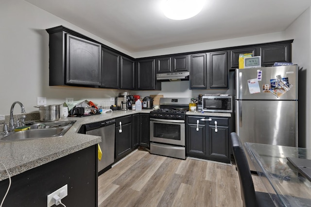 3092 Serenity Ln, Naperville, IL 60564 - kitchen with appliances with stainless steel finishes, a sink, under cabinet range hood, light wood-type flooring, and light countertops