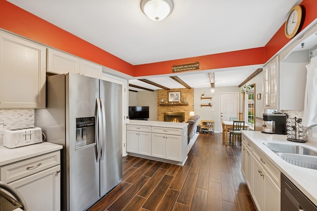 961 N Arrowhead Dr, Palatine, IL 60074 - kitchen featuring appliances with stainless steel finishes, a brick fireplace, open floor plan, tasteful backsplash, and light countertops