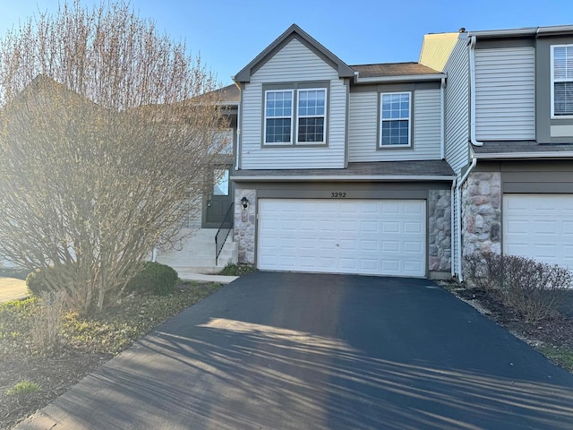 3292 Bromley Ln, Aurora, IL 60502 - view of front of home with an attached garage, driveway, stone siding, and roof with shingles