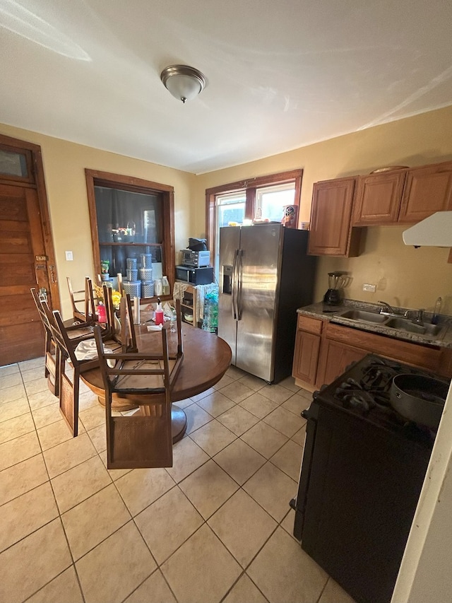 2853 W 40th St, Chicago, IL 60632 - kitchen featuring black gas stove, stainless steel fridge with ice dispenser, range hood, a sink, and light tile patterned floors