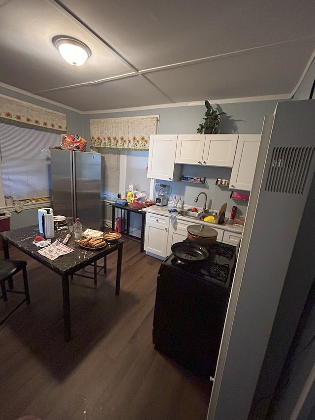2853 W 40th St, Chicago, IL 60632 - kitchen with freestanding refrigerator, white cabinets, dark wood-style floors, light countertops, and a heating unit