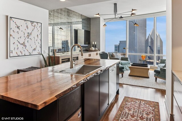 401 N Wabash Ave Unit 54E, Chicago, IL 60611 - kitchen with a sink, open floor plan, wood finished floors, an island with sink, and dark cabinets
