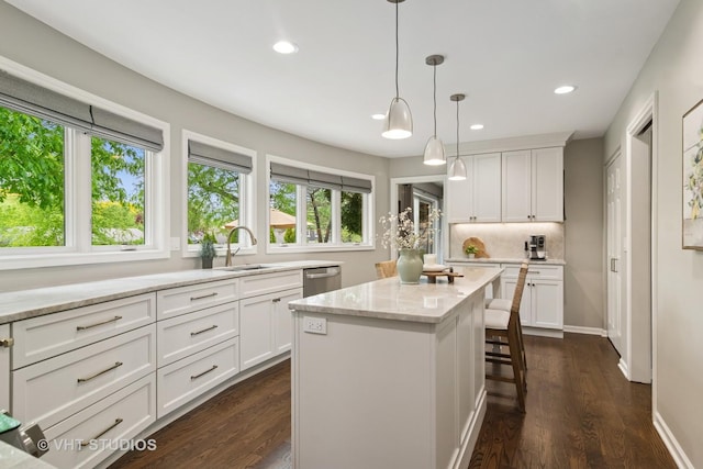 614 S Patton Ave, Arlington Heights, IL 60005 - kitchen featuring a sink, stainless steel dishwasher, white cabinets, recessed lighting, and a kitchen bar