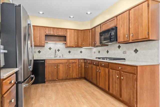 1025 Oxford Rd, Deerfield, IL 60015 - kitchen featuring black appliances, a sink, light wood-style floors, light countertops, and brown cabinetry