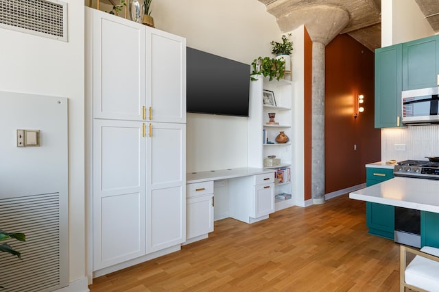 320 E 21st St Unit 402, Chicago, IL 60616 - kitchen featuring appliances with stainless steel finishes, open shelves, light wood finished floors, and light countertops