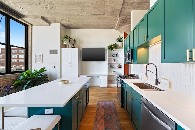 320 E 21st St Unit 402, Chicago, IL 60616 - kitchen featuring appliances with stainless steel finishes, a sink, light wood finished floors, light countertops, and tasteful backsplash