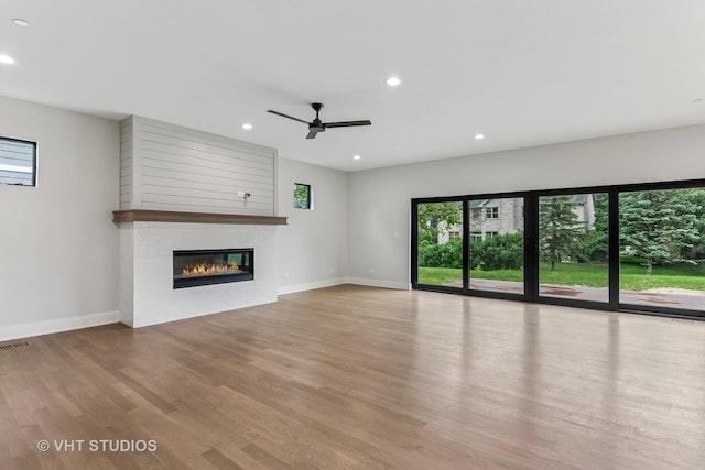 1527 N Louise Ln, Palatine, IL 60067 - unfurnished living room with healthy amount of natural light, wood finished floors, a fireplace, recessed lighting, and a ceiling fan
