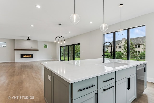 1527 N Louise Ln, Palatine, IL 60067 - kitchen featuring light wood-type flooring, a center island with sink, recessed lighting, pendant lighting, and gray cabinetry