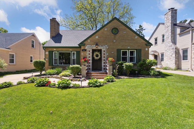 404 Vale Ave N, Rockford, IL 61107 - english style home with a front yard, brick siding, and a chimney