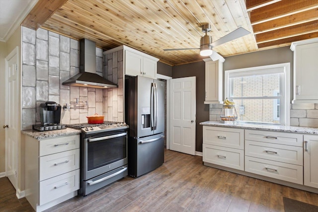 404 Vale Ave N, Rockford, IL 61107 - kitchen with stainless steel appliances, wall chimney range hood, ceiling fan, backsplash, and wood finished floors
