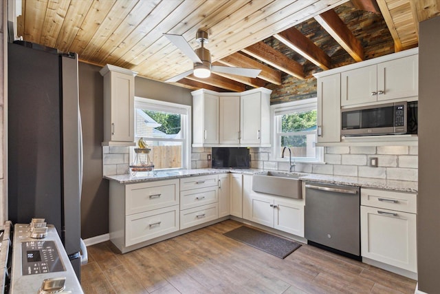 404 Vale Ave N, Rockford, IL 61107 - kitchen with stainless steel appliances, healthy amount of natural light, wood ceiling, a sink, and backsplash