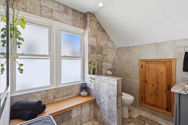 404 Vale Ave N, Rockford, IL 61107 - bathroom featuring lofted ceiling, toilet, tile walls, and vanity