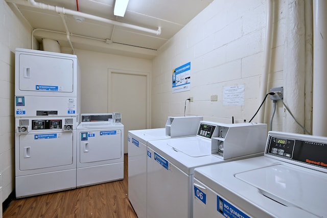 1806 Hemlock Pl Unit 105, Schaumburg, IL 60173 - shared laundry room featuring washing machine and dryer, concrete block wall, wood finished floors, and stacked washing machine and dryer