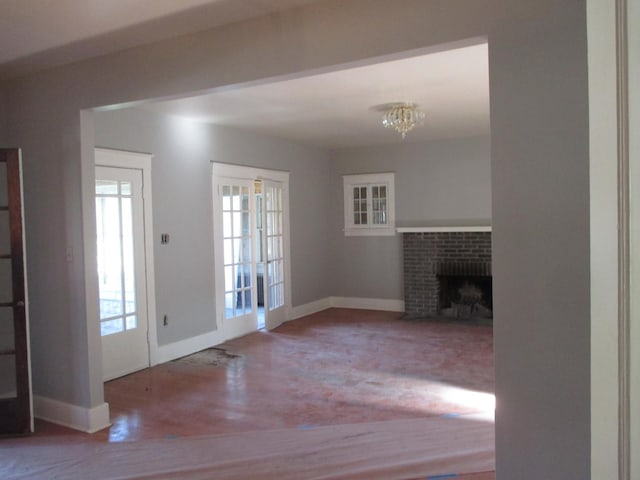 312 Union St, Joliet, IL 60433 - unfurnished living room featuring wood finished floors, baseboards, a fireplace, and a chandelier