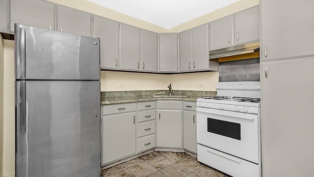 400 E Randolph St Unit 3321, Chicago, IL 60601 - kitchen featuring freestanding refrigerator, white gas stove, under cabinet range hood, a sink, and gray cabinetry