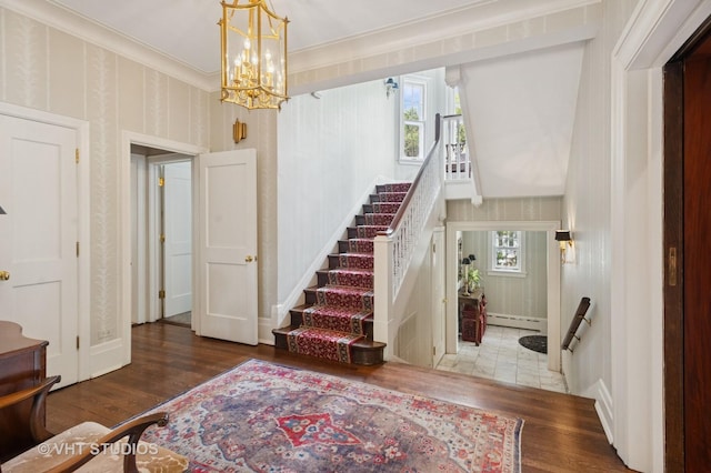 539 N E Ave, Oak Park, IL 60302 - entryway featuring baseboard heating, wood finished floors, a chandelier, stairs, and crown molding