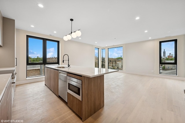 222 S Oakley Blvd Unit 3, Chicago, IL 60612 - kitchen featuring a sink, modern cabinets, appliances with stainless steel finishes, light wood finished floors, and plenty of natural light