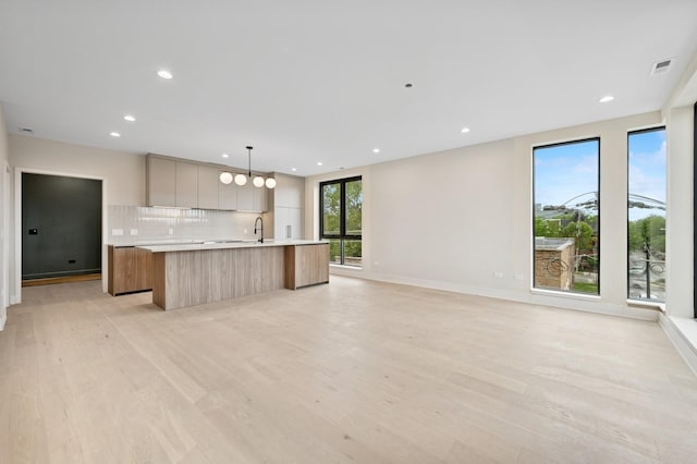 222 S Oakley Blvd Unit 3, Chicago, IL 60612 - kitchen with modern cabinets, a spacious island, light countertops, tasteful backsplash, and light wood finished floors