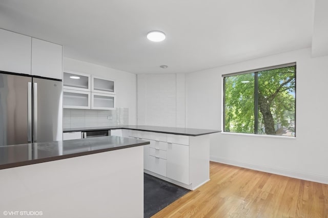 3759 N Kenmore Ave Unit A, Chicago, IL 60613 - kitchen with freestanding refrigerator, a peninsula, dark countertops, and white cabinetry
