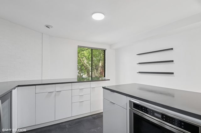 3759 N Kenmore Ave Unit A, Chicago, IL 60613 - kitchen featuring white cabinets, stainless steel oven, and dark countertops