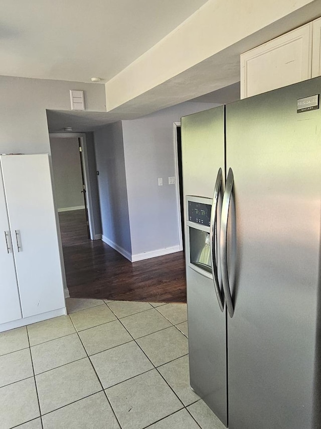 3238 Gresham Ln E, Aurora, IL 60504 - kitchen featuring stainless steel fridge, white cabinets, light tile patterned floors, and baseboards