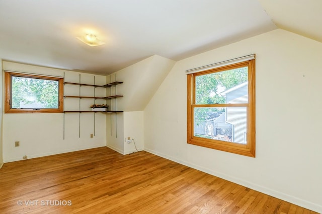 bonus room with vaulted ceiling, light wood finished floors, healthy amount of natural light, and baseboards