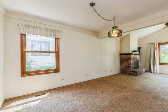 unfurnished living room with carpet floors, vaulted ceiling, a fireplace, and ceiling fan
