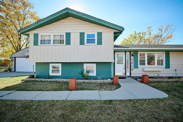 1613 Hartmann Dr, Schaumburg, IL 60193 - split level home featuring a front lawn, a detached garage, brick siding, and board and batten siding