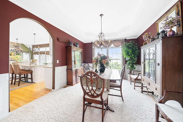 22802 Eider Ct, Plainfield, IL 60585 - dining room with a chandelier, a raised ceiling, a wainscoted wall, arched walkways, and ornamental molding