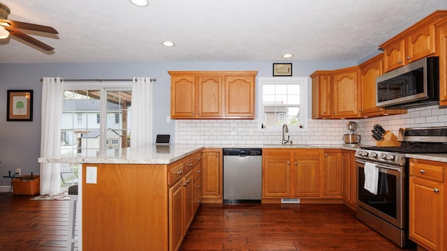 302 Gambel Ct, Normal, IL 61761 - kitchen with appliances with stainless steel finishes, a sink, a peninsula, a ceiling fan, and dark wood-style floors