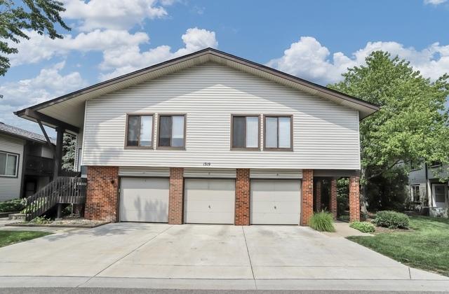 view of front facade with brick siding, driveway, and an attached garage