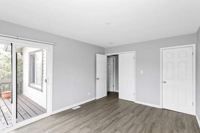 unfurnished bedroom with wood finished floors, baseboards, a closet, and access to exterior