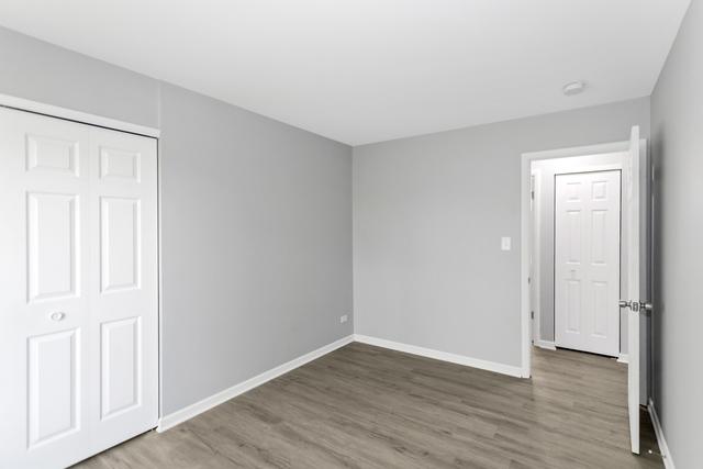 unfurnished bedroom with wood finished floors and baseboards