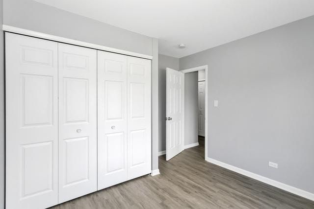 unfurnished bedroom featuring baseboards, wood finished floors, and a closet