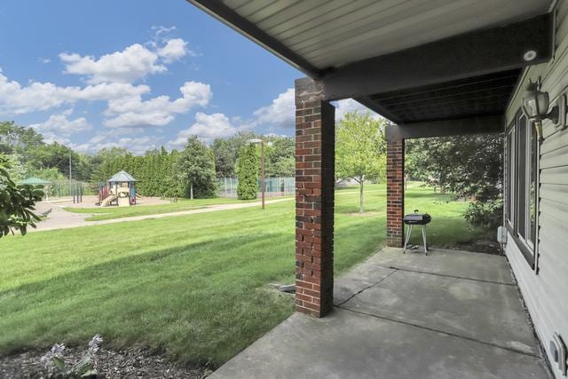 view of green lawn with a playground and a patio area