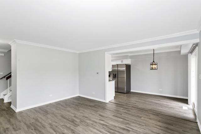 unfurnished living room featuring crown molding, dark wood finished floors, baseboards, and stairs
