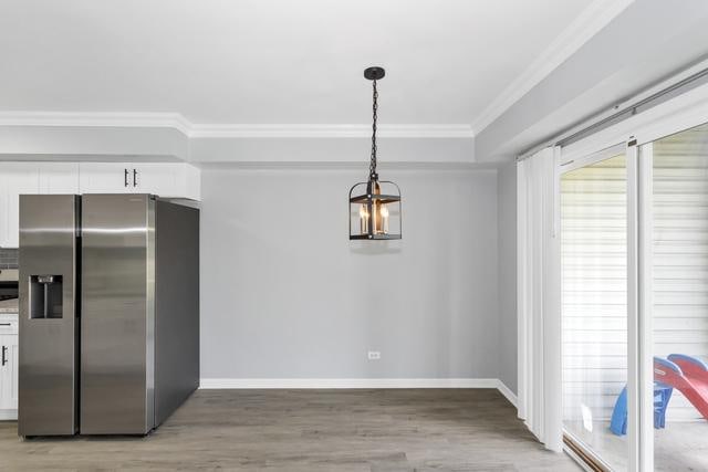 kitchen with stainless steel refrigerator with ice dispenser, crown molding, white cabinetry, light wood-style floors, and baseboards