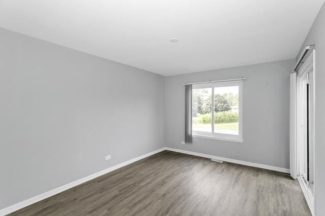 unfurnished bedroom featuring wood finished floors and baseboards