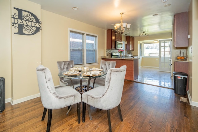 8743 S Constance Ave, Chicago, IL 60617 - dining room featuring a chandelier, dark wood-style flooring, and baseboards