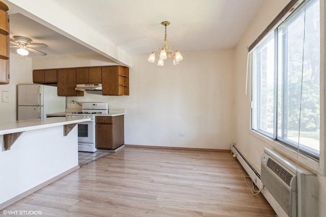 942 E Old Willow Rd Unit 101, Prospect Heights, IL 60070 - kitchen featuring white appliances, under cabinet range hood, healthy amount of natural light, and a baseboard radiator
