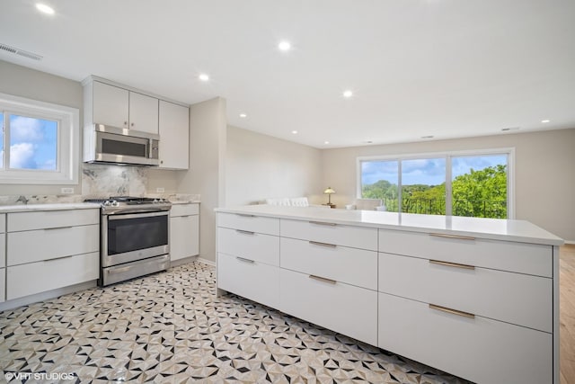 407 Ashland Ave Unit 6H, River Forest, IL 60305 - kitchen featuring appliances with stainless steel finishes, light countertops, white cabinetry, modern cabinets, and tasteful backsplash